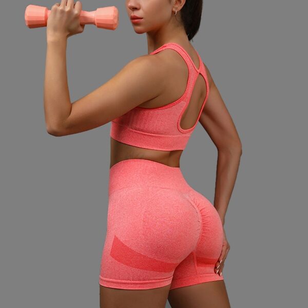 a women in pink outfit holding a dumbbell