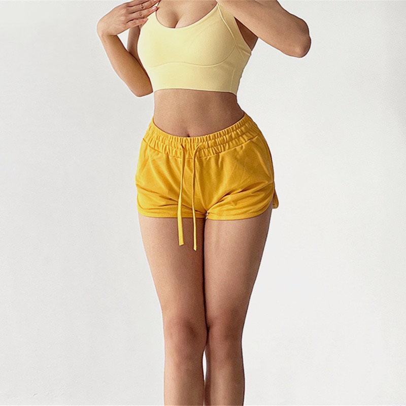 a women wearing yellow shorts and a tank top